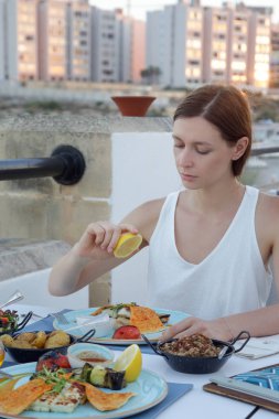 Akdeniz restoranında bir yemek üzerine limon sıkma kadın