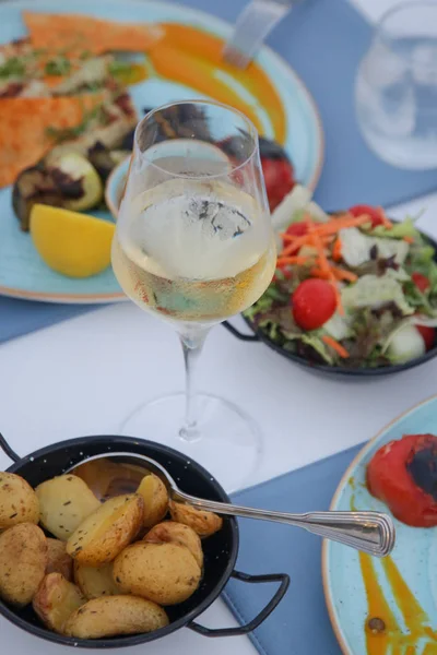 Ein Glas Weißwein Und Verschiedene Speisen Auf Dem Tisch — Stockfoto