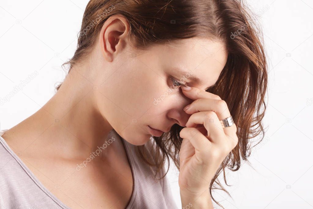 Studio shot of a young woman suffering from symptoms of sinus Infection (Sinusitis)