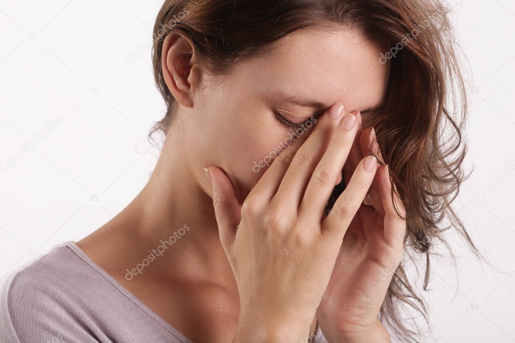Studio shot of a young woman suffering from symptoms of sinus Infection (Sinusitis)