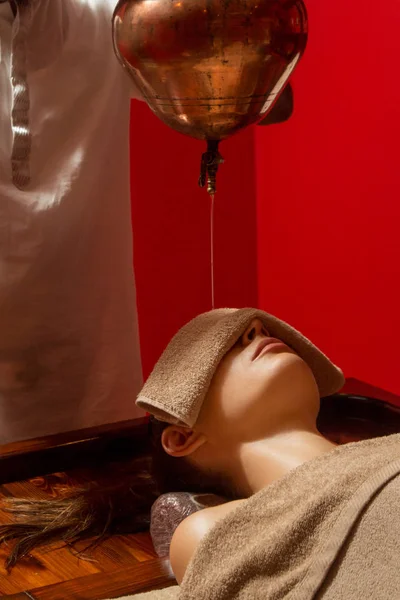 阿育吠陀治疗技术 油滴在女性额头上 一位年轻女子的肖像 在一次阿育吠陀按摩会议上 她的额头和头发上滴着芳香油 — 图库照片