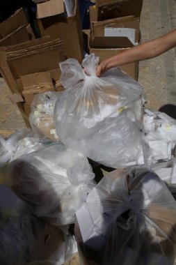 Beyaz plastik çöp torbaları ve çöp sokakta yığılmış