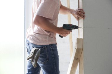 Elektrikli tornavida ile alçıpan içine sondaj vidaları süreci, ev geliştirme kavramı