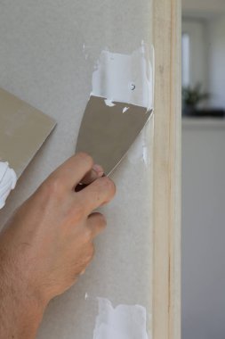 Macun bıçağı ile duvar sıva süreci. Duvar yüzeyinin sabitlenmesi ve boyama için hazırlık, ev yenileme konsepti