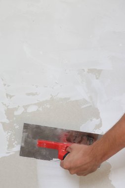 Macun bıçağı ile duvar sıva süreci. Duvar yüzeyinin sabitlenmesi ve boyama için hazırlık, ev yenileme konsepti