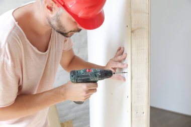 Handyman sondaj vidaları bir elektrikli tornavida ile alçıpan içine, ev geliştirme kavramı