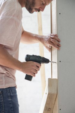 Handyman sondaj vidaları bir elektrikli tornavida ile alçıpan içine, ev geliştirme kavramı