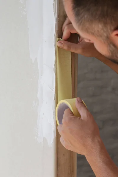 男人把胶带贴在墙上 简单步骤的快速和容易的绘画过程 装修房屋概念 — 图库照片