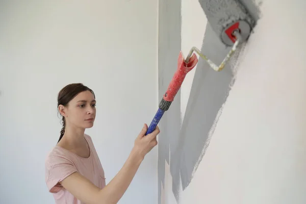 Kobieta Malując Szarą Farbą Białej Ścianie — Zdjęcie stockowe