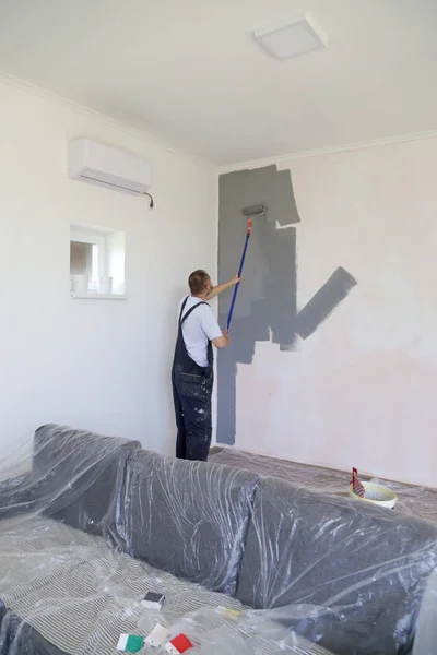 Hombre Pintando Con Pintura Gris Sobre Una Pared Blanca — Foto de Stock