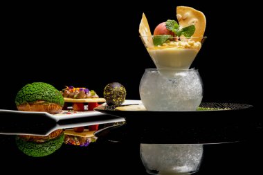 Çikolata krema ve buz üzerinde panna cotta ile doldurulmuş chou topuz ile koyu çikolatalı yumurta. Yaratıcı restoran tatlı konsepti. Haute couture gıda. Kaliteli yemek konsepti.