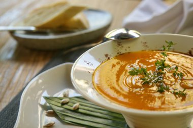 Restoran sofralarında ekmekle birlikte kavrulmuş kabak kremalı çorba servis edilir. Nefis yemek. Yaratıcı restoran yemeği. Kaliteli yemek konsepti.