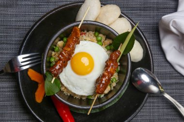 Nasi goreng - tavuk satay ve kızarmış yumurta ile kızarmış pilav. Nefis yemek. Yaratıcı restoran yemek konsepti.