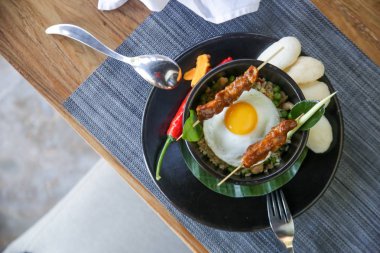 Nasi goreng - tavuk satay ve kızarmış yumurta ile kızarmış pilav. Nefis yemek. Yaratıcı restoran yemek konsepti.