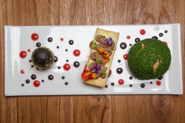 Çikolata krema ile doldurulmuş chou topuz ile koyu çikolatalı yumurta. Yaratıcı restoran tatlı konsepti.