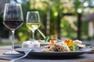 Gevrek ördek bacakları arugula ile servis edilir ve yenilebilir çiçeklerle dekore edilmiştir. Nefis yemek. Yaratıcı restoran yemek konsepti.