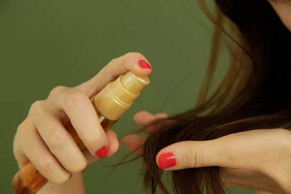 Woman applying oil on hair ends, split hair tips, dry hair or sun protection concept