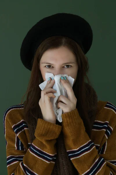 感冒或过敏症状 工作室拍摄的年轻女子有过敏症状打喷嚏到组织 年轻女子吹鼻子到白纸组织穿着冬衣 — 图库照片