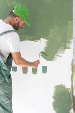 Beyaz bir duvar üzerinde yeşil boya ile adam boyama
