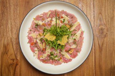 İtalyan ot pansuman ile Tuna carpaccio ahşap masada servis. Nefis yemek. Yaratıcı restoran yemek konsepti.