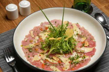 İtalyan ot pansuman ile Tuna carpaccio ahşap masada servis. Nefis yemek. Yaratıcı restoran yemek konsepti.