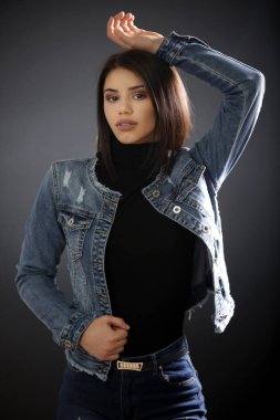 Siyah gömlekli güzel bir esmerin stüdyo portresi. Tarafsız bir yüz ifadesi.