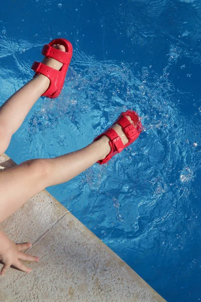 Kind Sitzt Beckenrand Und Planscht Schwimmbad Kinderbeine Mit Roten Gummisandalen — Stockfoto