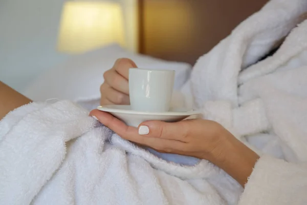 Beyaz Bornozlu Bir Kadın Yatak Odasında Kahve Içiyor — Stok fotoğraf