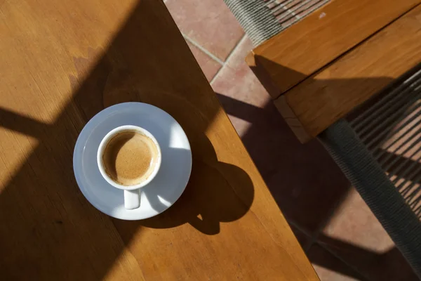 強い影を持つ木製のテーブルの上のコーヒーカップ トップビュー — ストック写真