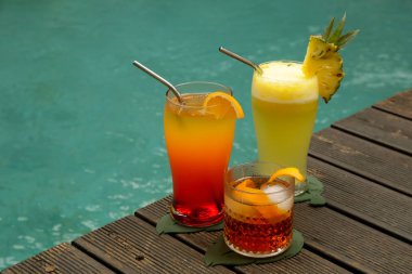 Yaz serinletici içecekler, havuzun kenarında bardaklar.