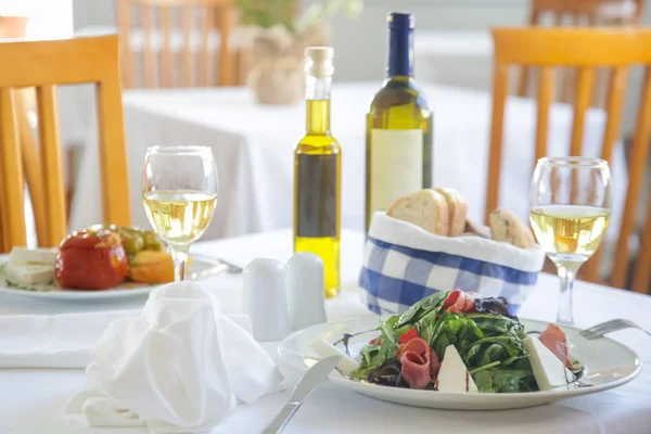 Delicious vegetarian dishes and white wine served on the restaurant table