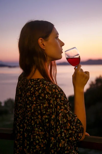 赤ワイングラスを飲む女性と美しい夕日を見て — ストック写真