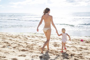 Anne kumsalda küçük kızıyla eğleniyor. Mutlu aile tatilleri..