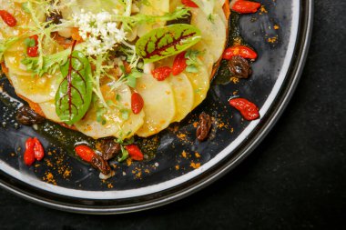 Enfes bir yemek. Güzellik böceği sağlıklı organik gıdaları süsledi. Modern yaratıcı restoran yemeği. Salata yaprakları ve goji meyveleriyle süslenmiş turp ve havuç püresi..