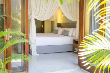 A view to a beautiful bedroom with king size bed through balcony door