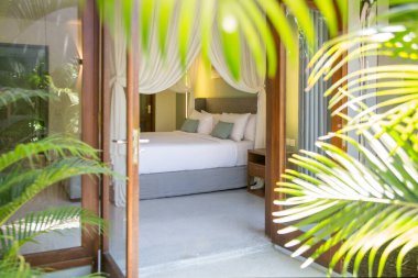 A view to a beautiful bedroom with king size bed through balcony door