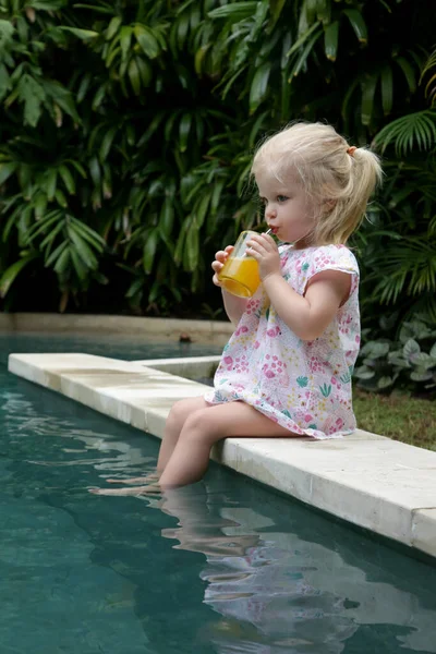 Χαριτωμένο Κοριτσάκι Που Κάθεται Στην Άκρη Της Πισίνας Και Πίνει — Φωτογραφία Αρχείου