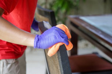 Corona virüsüne karşı ev yüzeylerini temizlemek ve dezenfekte etmek. Evi sprey deterjan, lastik eldiven ve bulaşık beziyle temizliyor. COVID-19 önleme içeride dezenfekte ediliyor.