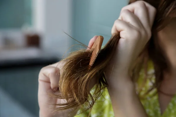 Saç Bakımı Esmer Kadın Ahşap Tarakla Karışık Saçlarını Tarıyor — Stok fotoğraf