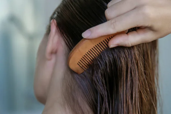 ヘアケア 濡れた髪と木の櫛を持つブルネットの女性 — ストック写真