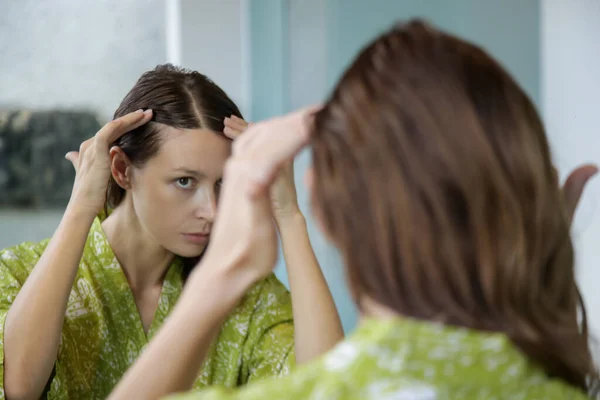 鏡の前で彼女の頭皮と髪を調べる美しい若い女性の肖像画 髪の根 脱毛や乾燥頭皮の問題 — ストック写真