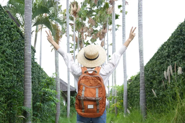 度假时戴草帽 背着橙色背包的观光客妇女的回顾 — 图库照片