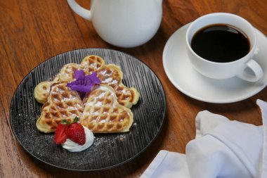 Tahta masada çay ile servis edilen Belçika waffleları.