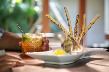 Lokanta masasında servis edilen tuzlu çubuklar ve buzlu çay..