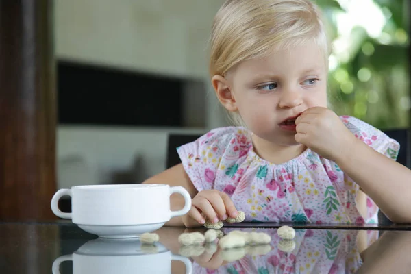 Småbarn Flicka Äter Jordnötter Med Skal Köksbordet — Stockfoto