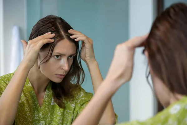 一个年轻貌美的女人在镜子前检查她的头皮和头发 灰白头发 脱发或干枯的头皮问题的画像 — 图库照片