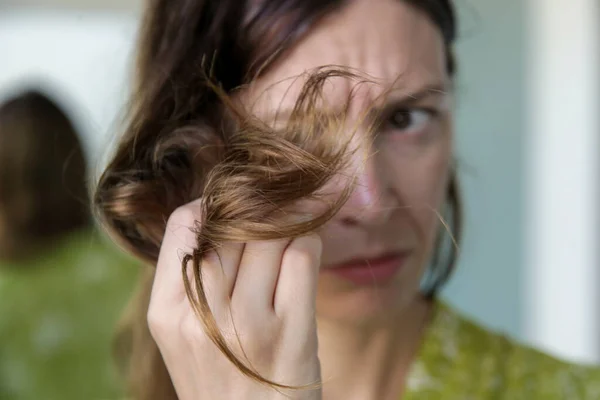 Kvinna Tittar Hennes Torra Och Trassliga Hårtoppar — Stockfoto