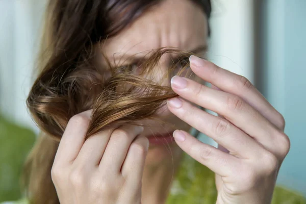 女人看着她干枯纠结的头发 — 图库照片