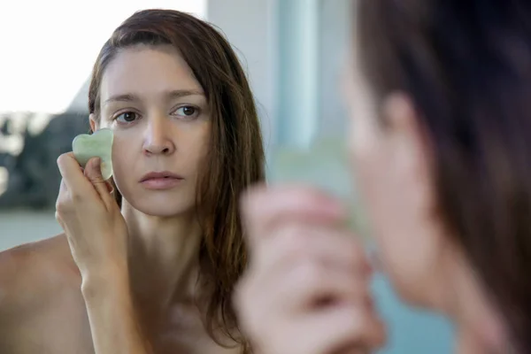 Ung Kvinna Gör Gua Sha Ansiktsmassage Badrummet Framför Spegeln Gua — Stockfoto