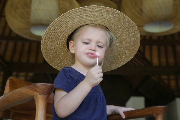 Откровенный Снимок Очаровательной Блондинки Малышки Соломенной Шляпе Поедающей Конфетный Леденец — стоковое фото